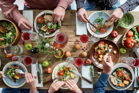 Aerial view of people eating healthy food on a wooden table