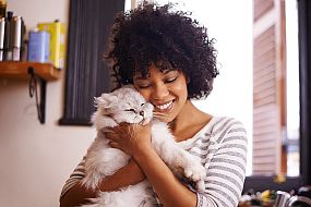 Curly girl cuddling her cat