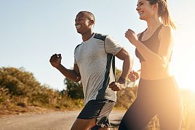 Two friends jogging together at sunset