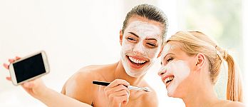 Two girl friends with face masks on taking a selfie Two girl friends with face masks on taking a selfie